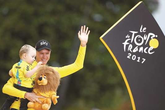 Team Sky rider Chris Froome of Britain celebrates his win in the Tour de France with his son Kellan on the podium in Paris yesterday. (Reuters)