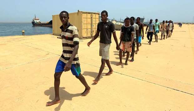Illegal migrants from Africa, walk at a port in Tripoli prior to being taken to a naval base after they were rescued by Libyan coastguards in the Mediterranean Sea off the Libyan coast