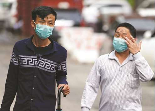 Locals walk on the street in Yangon, wearing face masks to protect themselves from the H1N1 virus.