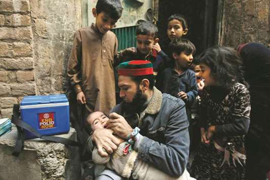 File photo: A Pakistani health worker vaccinates a child against polio in Peshawar.