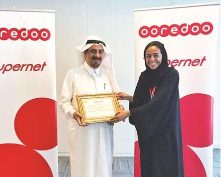 Manar Khalifa al-Muraikhi receives the award from Mohamed Abdulrahman al-Sayed.