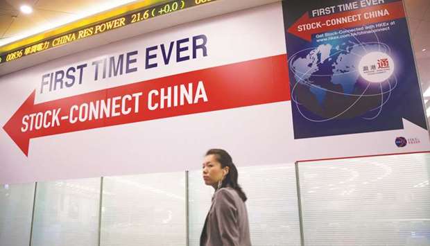 A woman walks past a banner reading u2018First Time Ever, Stock-Connect Chinau2019 in Hong Kong. Foreign investors have proved to be good stock pickers so far when it comes to their newest entry channel for Chinese stocks, but things may get rougher the rest of this year.