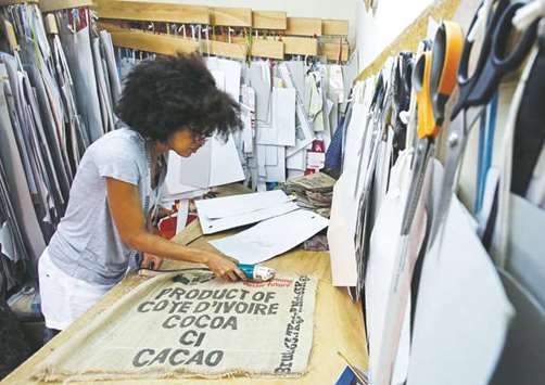 Fashion designer Liliane Estievenart works on cocoa sacks inside her workshop in Abidjan.