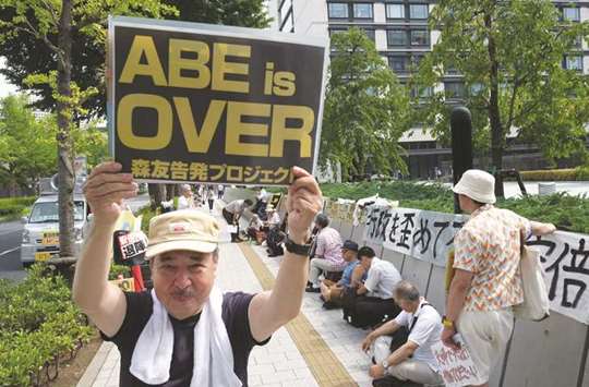 A protester holds up a placard that reads u2018Abe is Overu2019 during a rally against Prime Minister Shinzo Abe in front of the parliament in Tokyo.