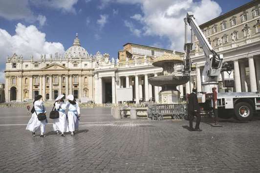 Nuns walks past an empty fountain in St Peteru2019s Square.