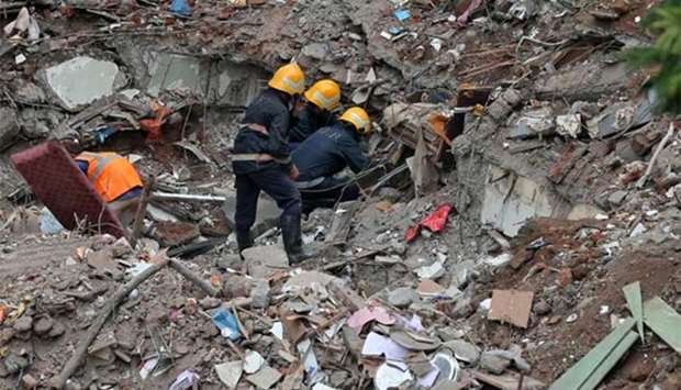 Firefighters remove debris as they search for survivors at the site of a collapsed building in the suburbs of Mumbai on Wednesday.