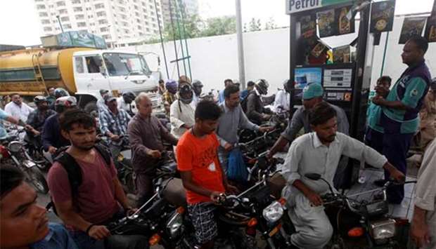 Customers wait to buy petrol at a fuel station in Karachi on Wednesday.