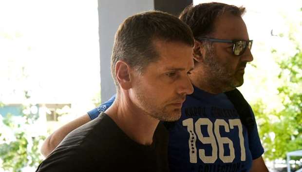 Alexander Vinnik, a 38 year old Russian man (L) suspected of running a money laundering operation, is escorted by a plain-clothes police officer to a court in Thessaloniki, Greece July 26, 2017.