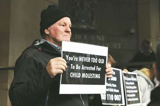 A protester holds a placard at the Melbourne Magistrates Court in Melbourne.
