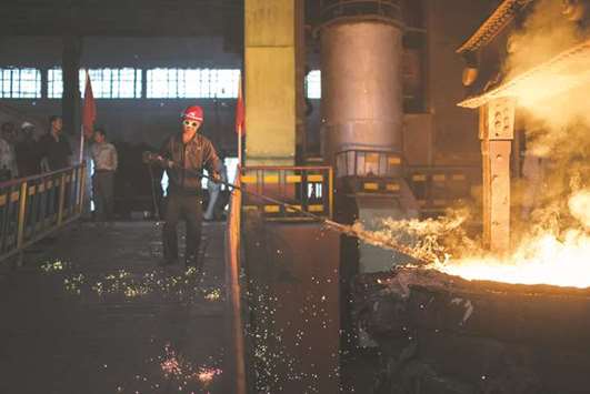A worker checks the temperature of molten steel during production at the Chollima Steel Complex, south-west of Pyongyang.