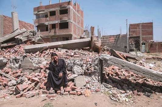A recent photo shows Egyptian Shoukran Rashwan, 75, sitting on the rubble of her house that was demolished in Cairou2019s Warraq island.