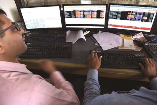 Indian stock traders watch share prices on their terminals at a brokerage house in Mumbai. Indiau2019s benchmark equity index gave up gains to close little changed on expiry of monthly derivatives contracts yesterday.