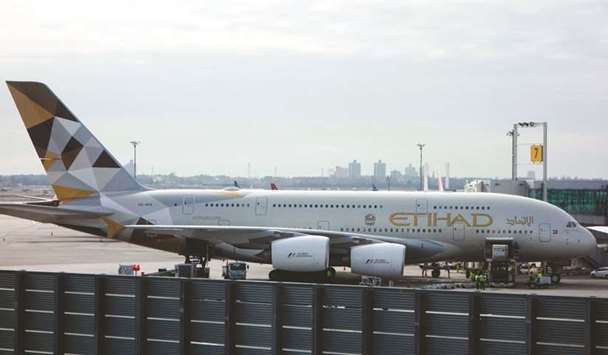 An Etihad Airways is seen parked at the terminal on March 21, 2017 at John F Kennedy International Airport in New York. The Abu Dhabi-based carrier has booked a $1.06bn charge from writing down the value of aircraft and a further $808mn hit from the reduced value of stakes in so called equity partners including struggling Air Berlin and Italyu2019s Alitalia, which filed for bankruptcy in May.