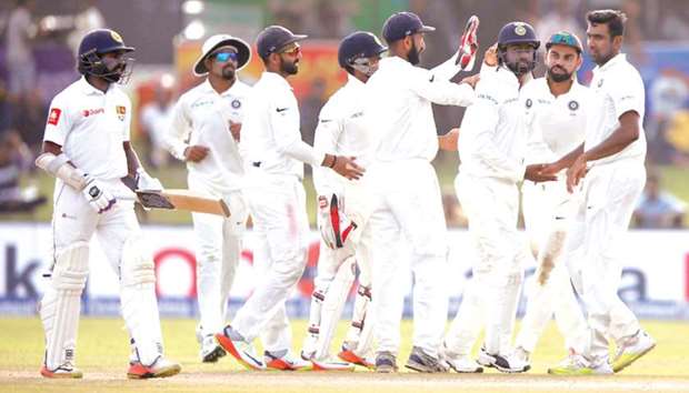 India captain Virat Kohli (second from right) and Ravichandran Ashwin (right) celebrate the wicket of Sri Lankau2019s Niroshan Dickwella with teammates on day two of the first Test in Galle, Sri Lanka, yesterday. (Reuters)
