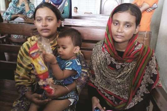 Nusrat Jahan (right), the biological mother of the child, and Rasheda Akter, the adopted mother, sit together at the court in Chittagong.
