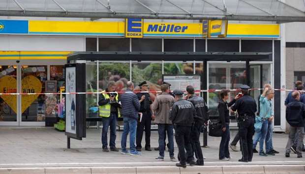 Police cordon off the area around a supermarket in the northern German city of Hamburg, where a man killed one person and wounded several others in a knife attack.