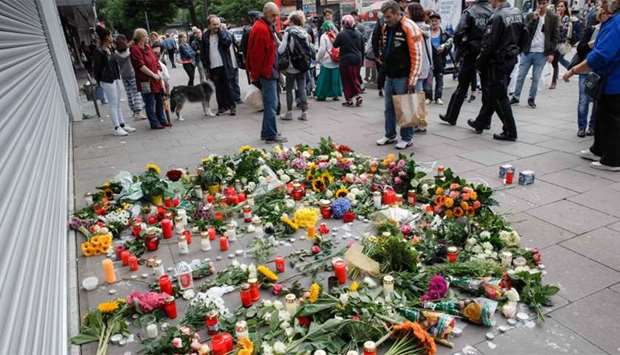 A makeshift memorial of flowers and candles is placed  in front of a supermarket in Hamburg