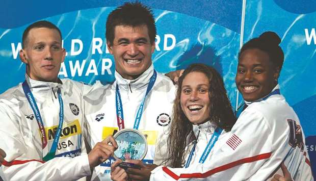 USAu2019s Caeleb Dressel, Nathan Adrian, Mallory Comerford and Simone Manuel celebrate on the podium after winning the mixed 4x100m freestyle final at the 2017 FINA World Championships in Budapest yesterday.
