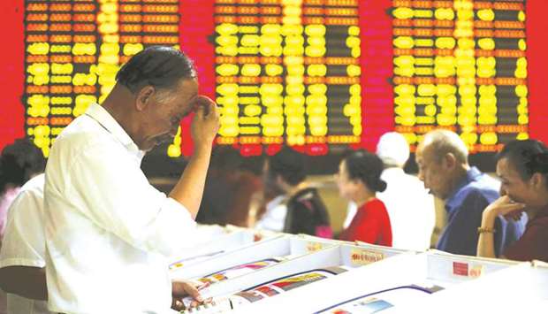 Investors look at computer screens showing stock information at a brokerage house in Shanghai. Chinese financial institutions are gaining greater clout in the international bond underwriting business, in a trend thatu2019s altering the lives of bankers from New York to Shanghai.