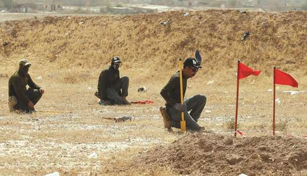Mine clearers search for mines and explosive devices at Hammam al-Alil city south of Mosul, Iraq.