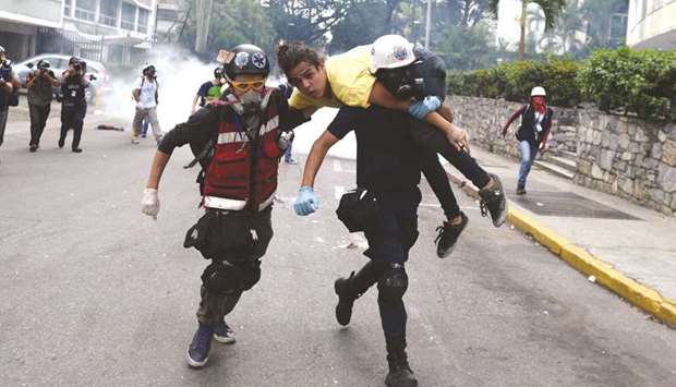An injured opposition activist is taken away by volunteer medics during protest against the government of President Nicolas Maduro, at the Francisco Fajardo highway in Caracas, on Saturday.