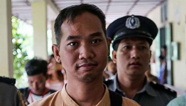 Swe Win (C), the editor of Myanmar Now, is escorted to a court by police