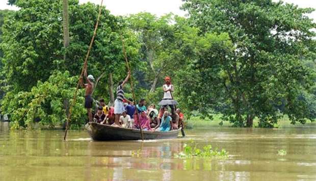 Indian flood victims on a boat make their way through flood waters after collecting relief materials in the Amta area of Howrah district, around 55km west of Kolkata.
