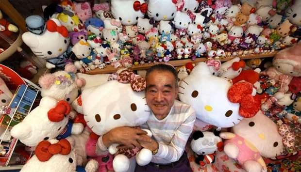 Retired Japanese police officer Masao Gunji posing with his Hello Kitty collection