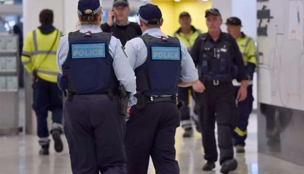 Police walk through the international terminal as they patrol Sydney Airport