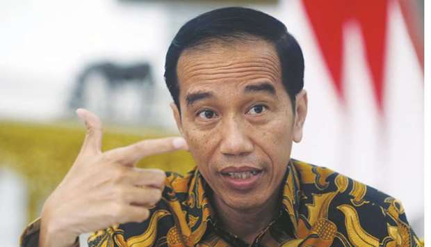 Indonesiau2019s President Joko Widodo gestures during an interview with Reuters in Jakarta. The government will ease foreign ownership restrictions on certain industry sectors in August, Widodo said.