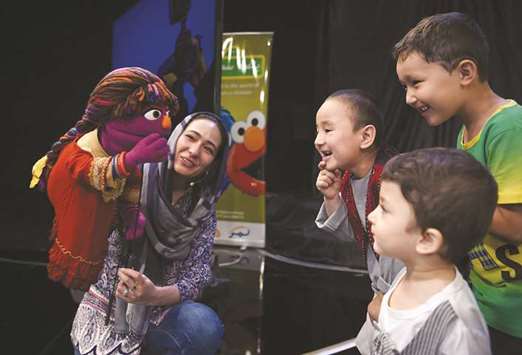In this photograph taken on July 2, 2017, Afghan children meet Sesame street Muppet u2018Zariu2019 after a recording at a television studio in Kabul.