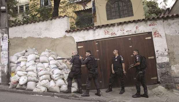 Policemen take up position after a resident was killed during a violent clash during an operation against drug dealers in Pavao Pavaozinho slum in Rio de Janeiro.