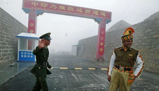 Chinese soldier (L) next to an Indian soldier at the Nathu La border crossing between India and Chin