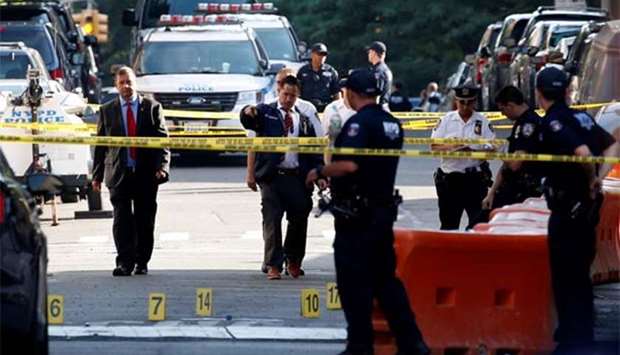 New York City Police Department officers work near a police vehicle where a gunman fatally shot a female New York City police officer in an unprovoked attack early on Wednesday in the Bronx borough.
