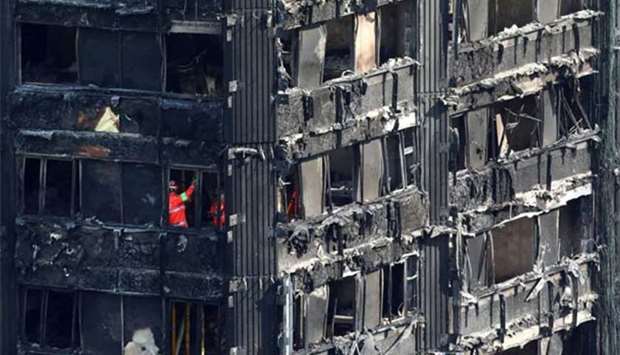 Members of the emergency services are seen working inside burnt out remains of the Grenfell apartment tower in London last month.