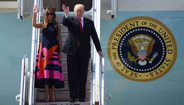 US President Donald Trump and First Lady Melania Trump wave as they step off Air Force One upon arrival in Hamburg on Thursday.