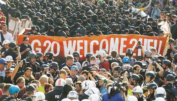 German riot police stand in front of protesters during the G20 summit in Hamburg, Germany.