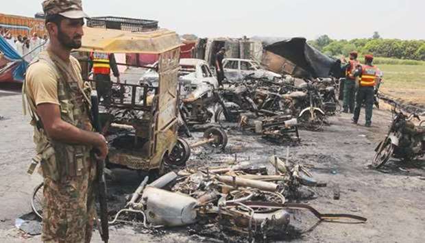 Pakistani soldiers stand guard beside burnt out vehicles at the scene where an oil tanker caught fire following an accident on a highway near the town of Ahmedpur East, some 670km from Islamabad. June 25, 2017 file picture.