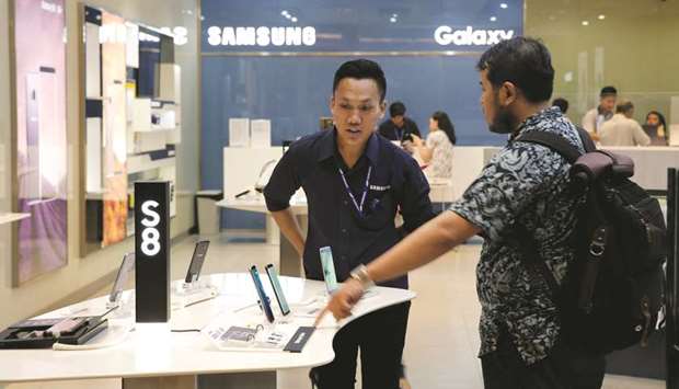 A salesperson serves a customer at a Samsung phone store in Jakarta, Indonesia. The company expects profits to soar 72% in the second quarter to a record high, it said yesterday, as it moves on from a recall debacle thanks to rising memory chip prices and increased demand for smartphones.
