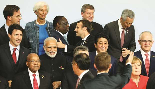 French President Emmanuel Macron (top, centre) greets Senegalu2019s President Macky Sall (3rd from left) as managing director of the International Monetary Fund Christine Lagarde (2nd from left), Netherlandsu2019 Prime Minister Mark Rutte (top left), Indiau2019s Prime Minister Narendra Modi (centre, 2nd from left), Japanu2019s Prime Minister Shinzo Abe (centre, 2nd from right) and Canadau2019s Prime Minister Justin Trudeau (centre, left) look on the first day of the G20 leaders summit in Hamburg, Germany, yesterday.
