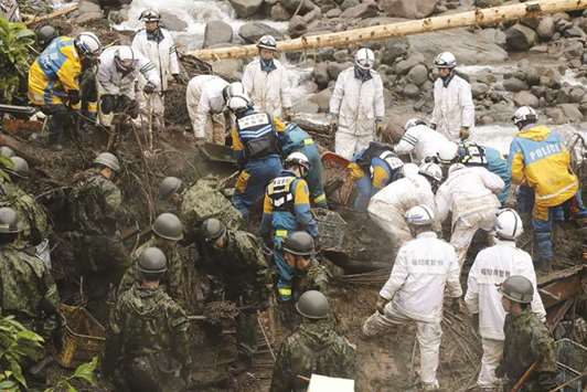 Japanese policemen and members of Self-Defence Forces (SDF) take part in search operations for missing people at a flood area in Toho village, Fukuoka prefecture, yesterday.