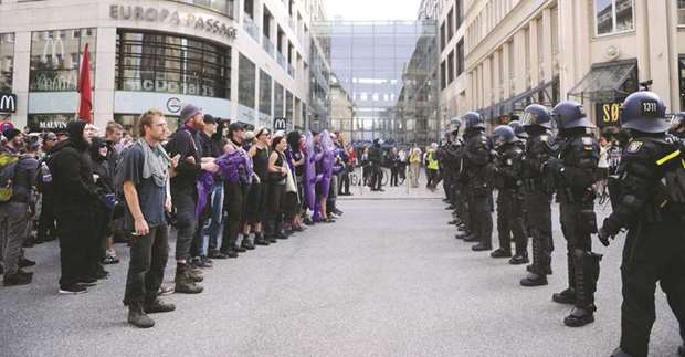 Demonstrators face policemen during a protest in Hamburg.