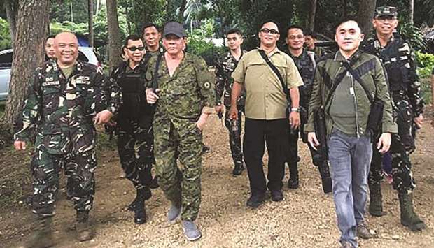 Handout photo released yesterday shows President Rodrigo Duterte wearing a military uniform while walking inside a military camp in Iligan City, Mindanao.