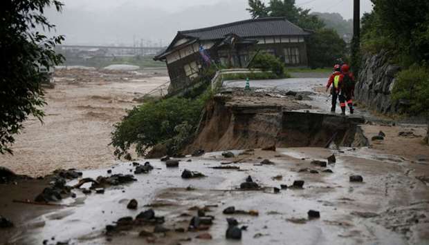 Rescue workers walk at an area hit by heavy rain at Haki district in Asakura, Fukuoka Prefecture, Japan.