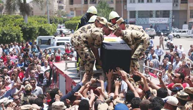 Egyptian soldiers carry the coffin of a soldier, who was killed a day earlier in the restive Sinai Peninsula in an attack by the Islamic State group, during a funeral ceremony in Ramadan city, about 60kms north of Cairo, yesterday.