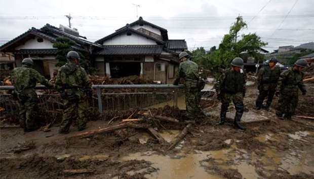 Japanese Self-Defence Force soldiers conduct search and rescue operation near houses damaged by a heavy rain in Asakura, Fukuoka Prefecture, on Sunday.