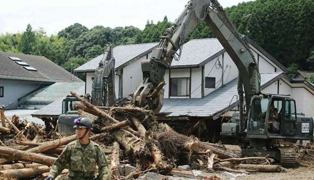 Defence forces soldiers remove debris in a flooded area in Asakura, Fukuoka prefecture.