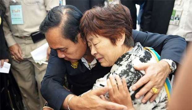Thailand's Prime Minister Prayuth Chan-ocha comforts a relative of Chinese tourists involved in a sunken tourist boat accident at a hospital in Phuket.