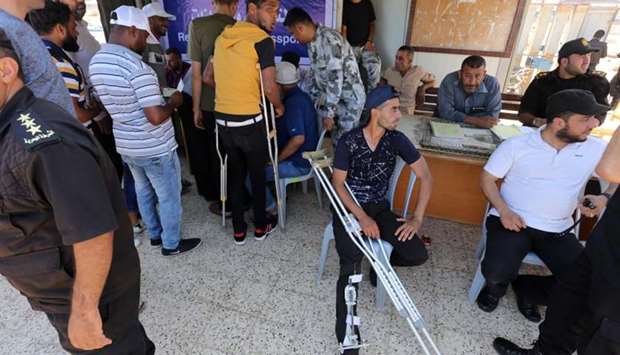 Hamas officials register the passport details of injured Palestinians preparing to board a blockade-running boat, carrying them with other students, out from the Gaza City harbour, to break Israel's naval blockade on the enclave.
