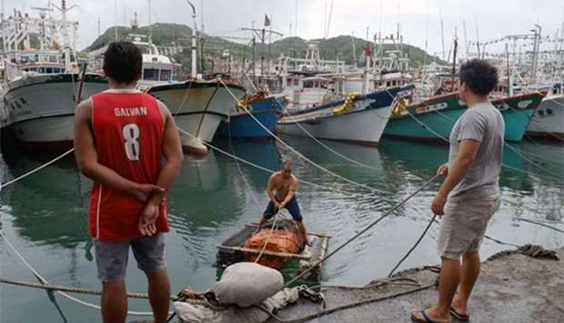 A fisherman navigates a raft near boats filling the Patoutzu Fishing Harbour in Keelung on Tuesday, as Typhoon Maria approaches northern Taiwan.
